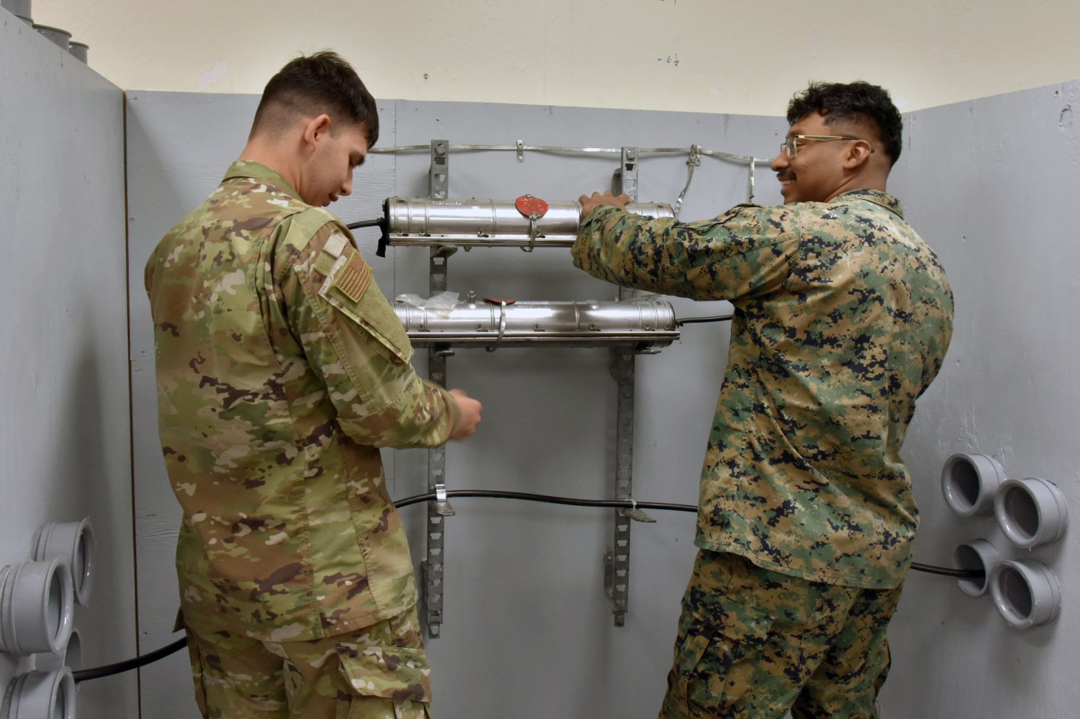 Two students at the 364th Training Squadron's Cable and Antenna Systems apprentice course use the confined space simulator Feb. 23, 2024 at Sheppard Air Force Base.