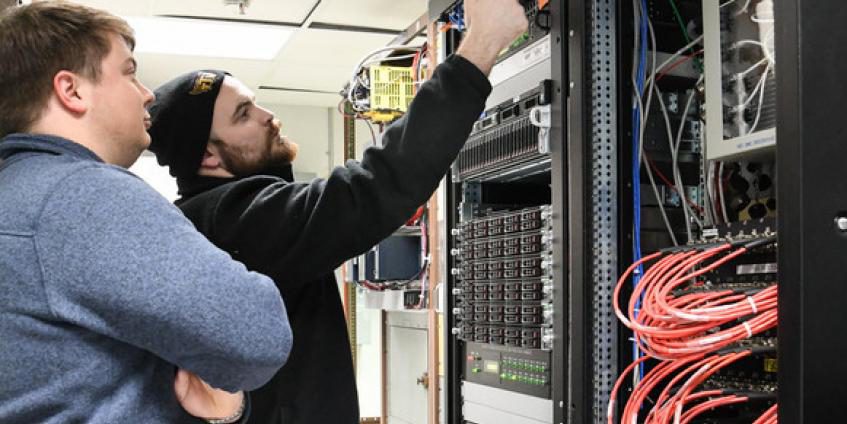 Dakota Aaron, right, an eSTARR hardware engineer, and Calvin Davis, an instrumentation, data, and controls engineer, check the new network switch and data source computers in the Arnold Engineering Development Complex Engine Test Facility T-3 test cell data conditioning room at Arnold Air Force Base on December 3. The network switch and data source computers are part of upgrades to the test cell, including the new digital voltage scanners at the right (U.S. Air Force photo by Jill Pickett).