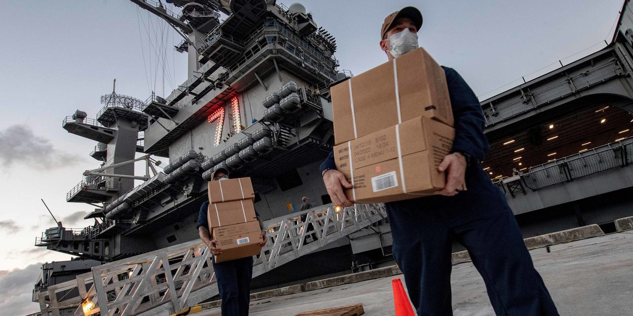 Sailors assigned to the aircraft carrier USS Theodore Roosevelt take meals to asymptomatic sailors who have tested negative for COVID-19 and are housed at local hotels in Guam, April 7, 2020.