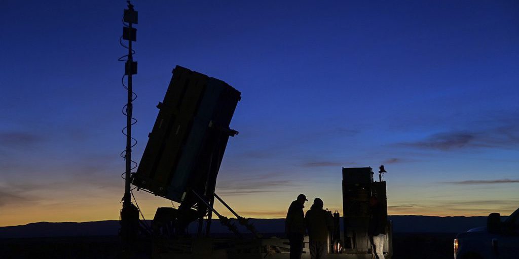 As dusk descends, Marines and civilians from the Program Manager for Ground-Based Air Defense assemble around Program Executive Officer Land System’s cutting-edge Medium Range Intercept Capability system.