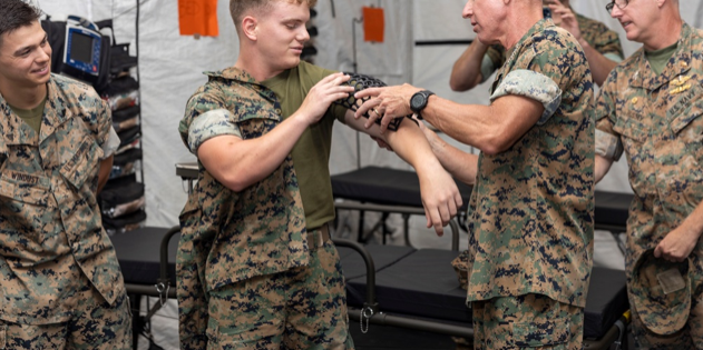The 36th Assistant Commandant of the Marine Corps, Gen. Eric M. Smith, right, fits a 3D printed cast to the arm of Lance Cpl. Micah Mosley, a network administrator from 1st Marine Logistics Group (MLG), 1st Marine Division, I Marine Expeditionary Force (MEF), on Camp Pendleton, California, August 17, 2023. The cast was manufactured by 1st Medical Battalion. General Smith visited 1st MLG as part of a command tour and to observe the logistical capabilities of I MEF (U.S. Marine Corps photo by Sgt. Rachaelanne Woodward).