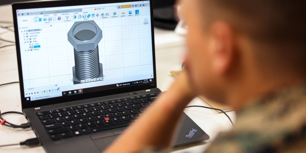 soldier viewing a CAD design on a laptop