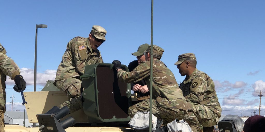 An acoustic hailing device (AHD) being installed on a High Mobility Multipurpose Wheeled Vehicle (HMMWV) (Source: U.S. Army Picatinny Arsenal).
