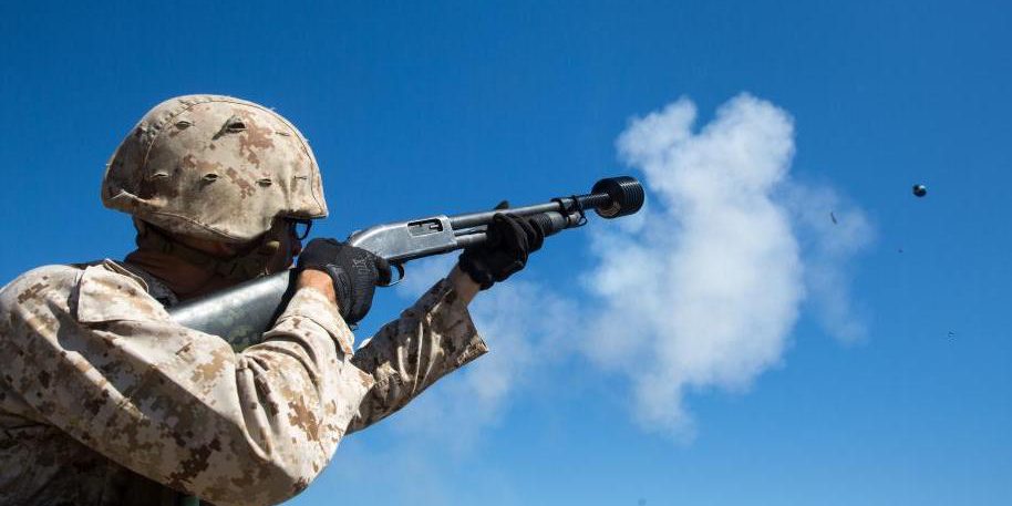 A Marine fires a flashbang grenade from a shotgun attachment, one of several non-lethal weapons under use by the U. S. Department of Defense (U.S. Navy photo).