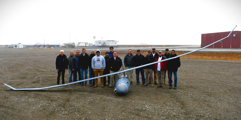 A team of researchers next to an unmanned aerial vehicle (UAV)