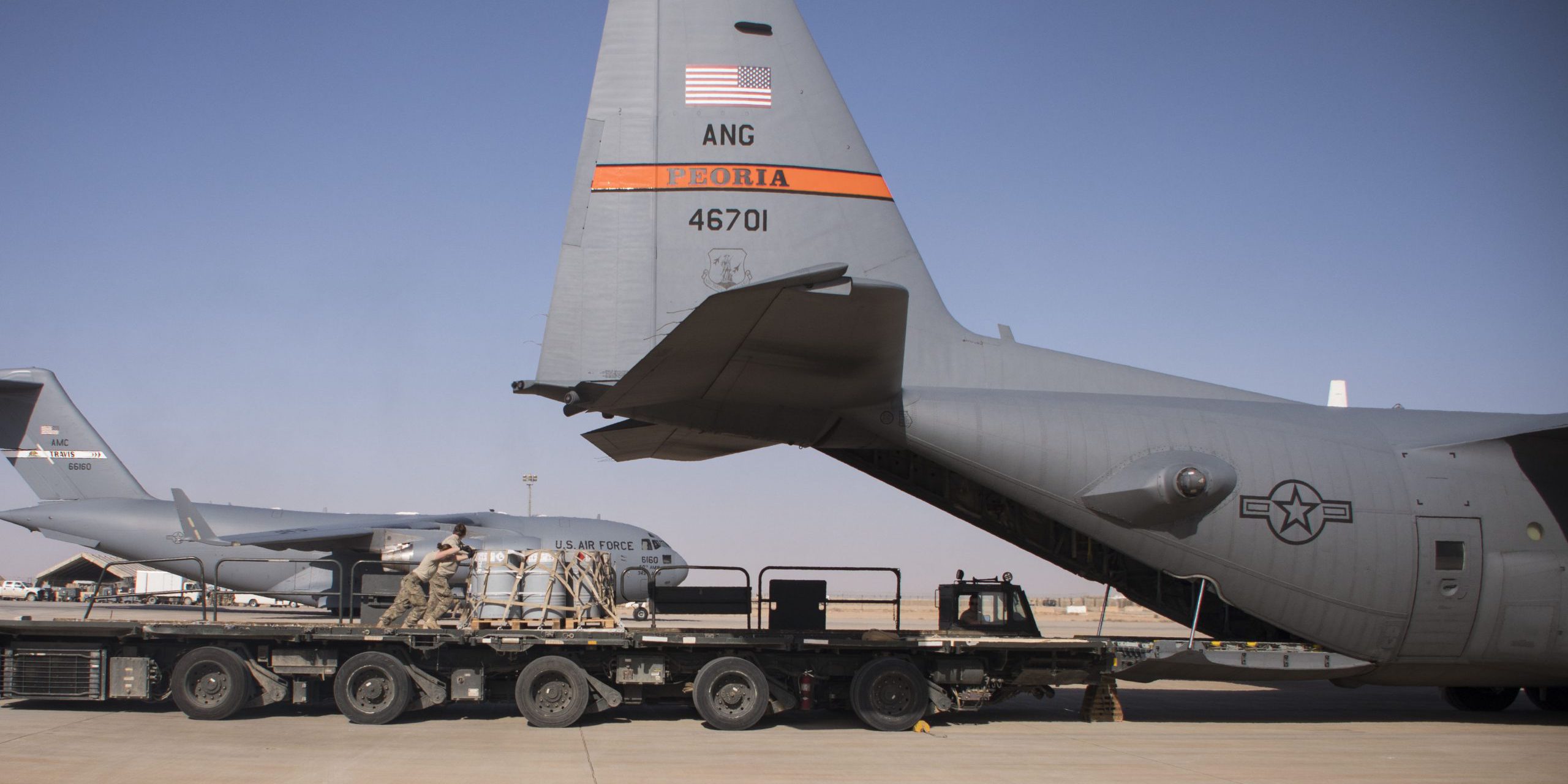 Aerial porters from the 870th Air Expeditionary Squadron push a pallet of supplies from a K-loader into the back of a C-130H Hercules at Al Asad Air Base, Iraq, Jan. 9, 2017. Aerial porters are responsible for loading and unloading aircraft and moving cargo around the cargo yard. (U.S. Air Force photo/Senior Airman Andrew Park)